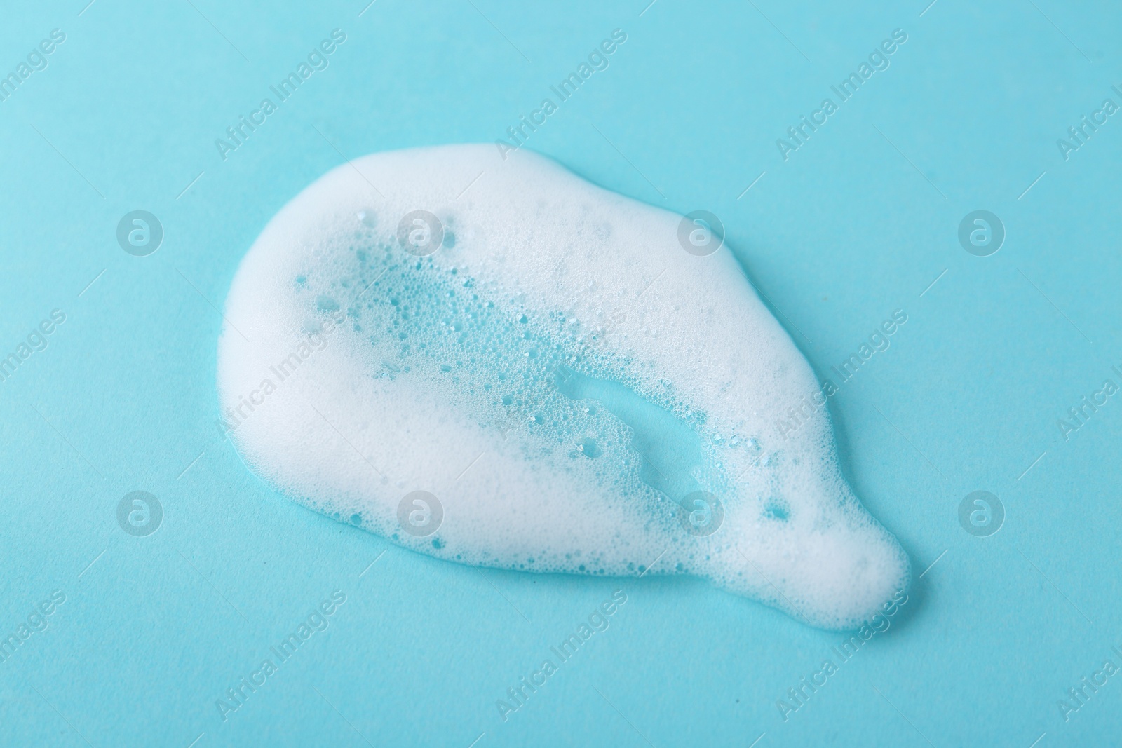 Photo of Sample of fluffy foam on light blue background, top view