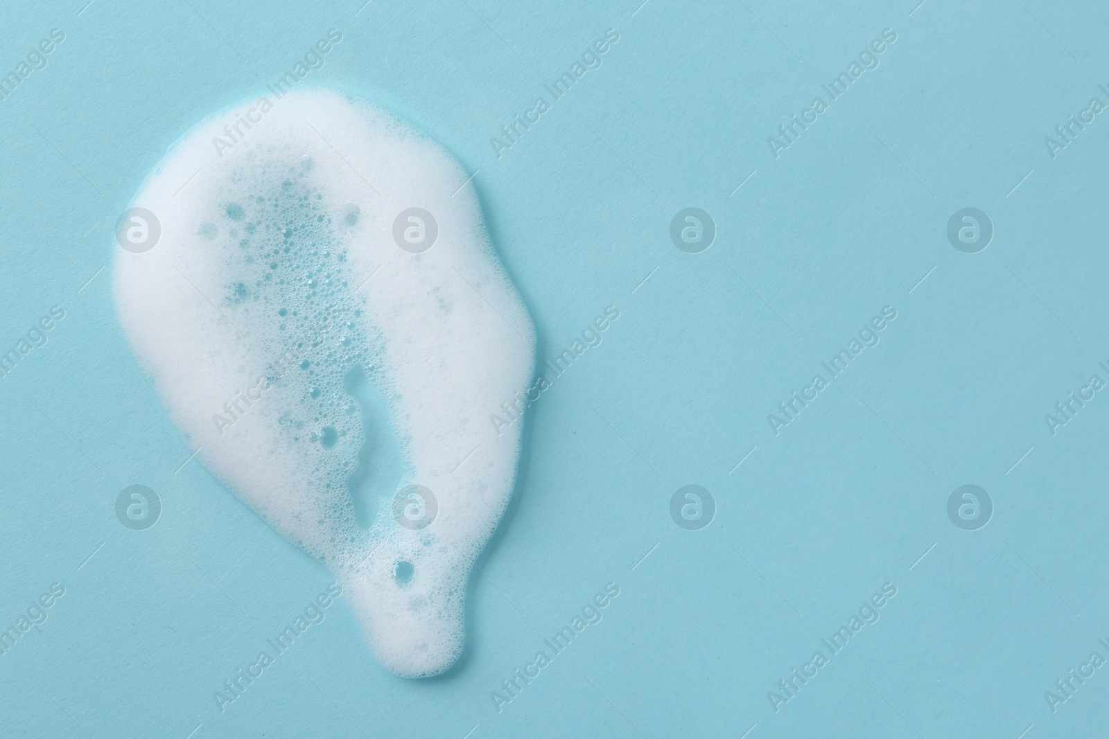 Photo of Sample of fluffy foam on light blue background, top view. Space for text