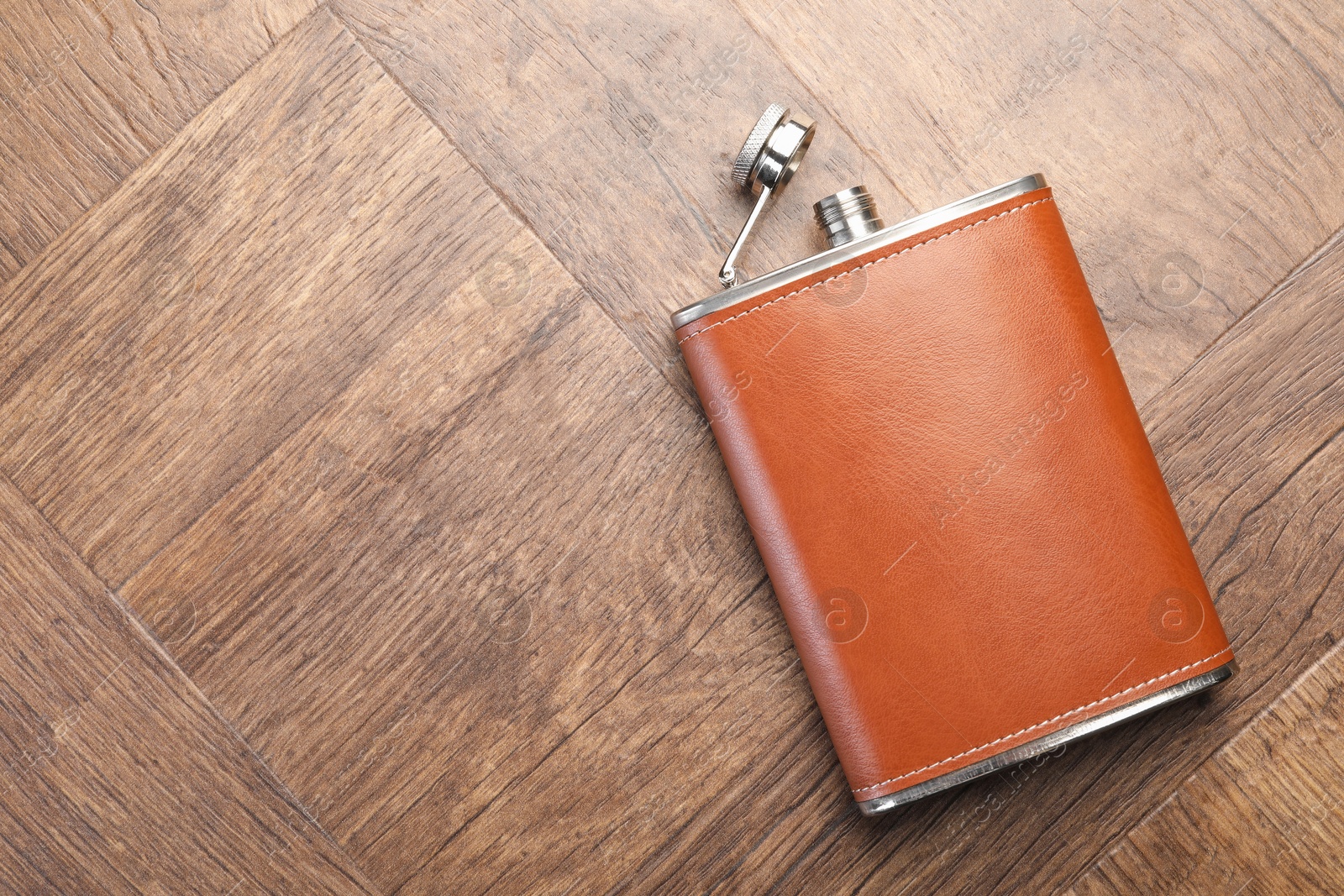 Photo of One hip flask on wooden table, top view. Space for text