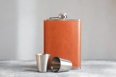 Photo of Hip flask and cups on grey table