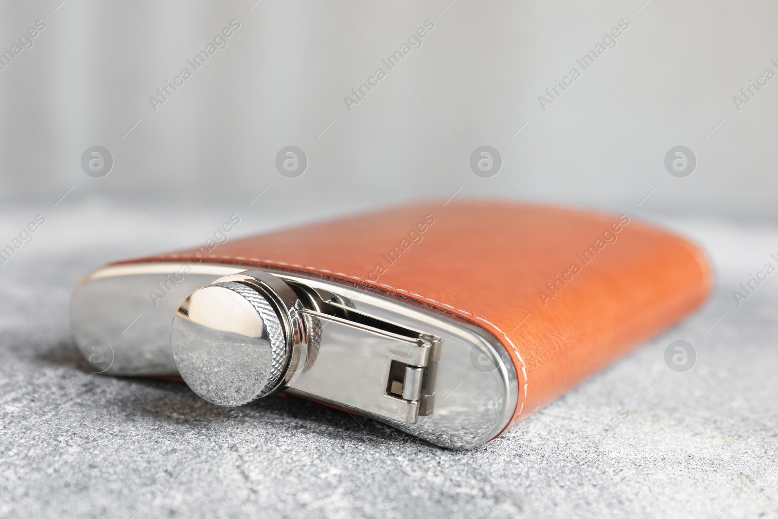 Photo of Hip flask on grey table, closeup view