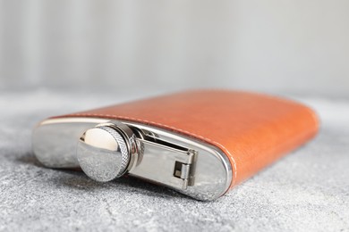 Photo of Hip flask on grey table, closeup view