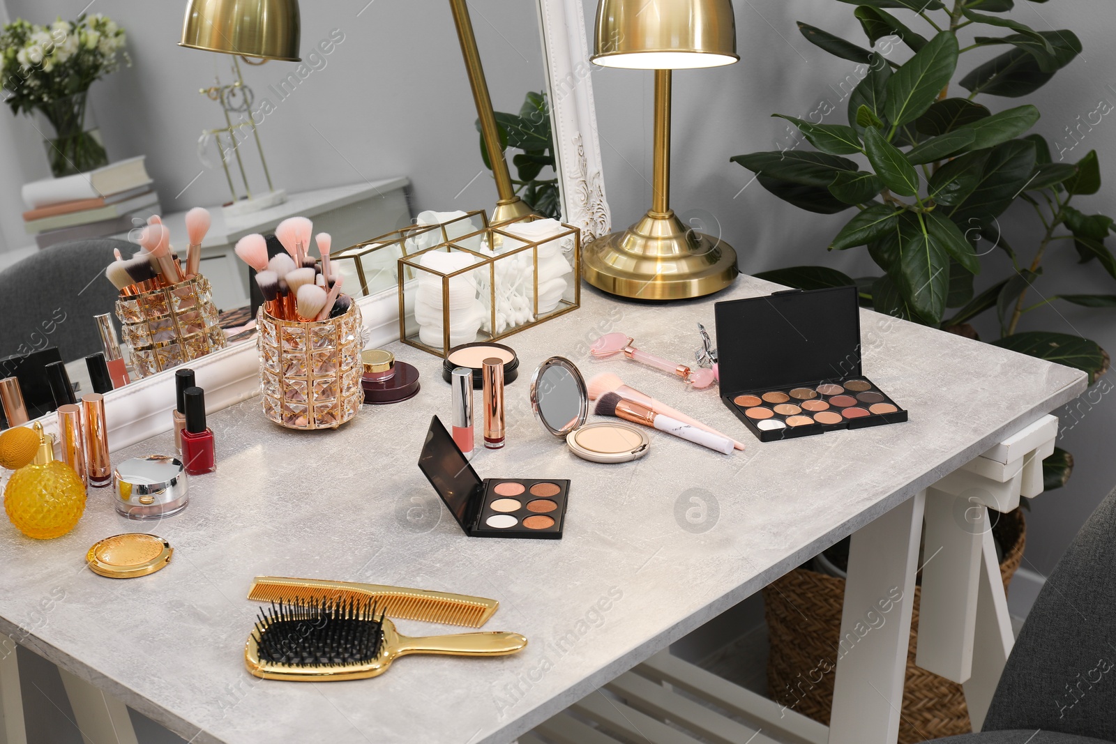 Photo of Makeup room. Different beauty products on dressing table and mirror indoors