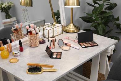 Photo of Makeup room. Different beauty products on dressing table and mirror indoors