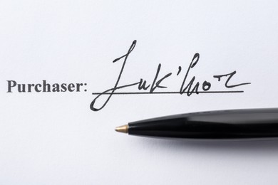 Photo of Signature and pen on paperwork, closeup view