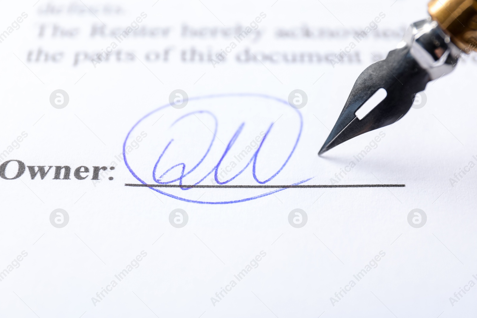 Photo of Signature and fountain pen on paperwork, closeup view