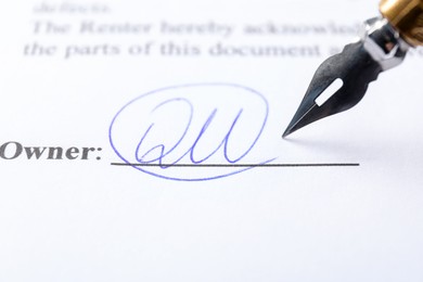 Photo of Signature and fountain pen on paperwork, closeup view