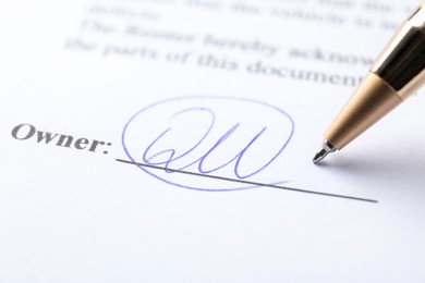 Photo of Signature and pen on paperwork, closeup view