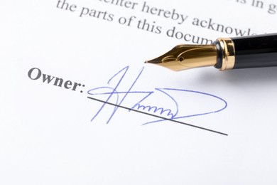 Photo of Signature and fountain pen on paperwork, closeup view