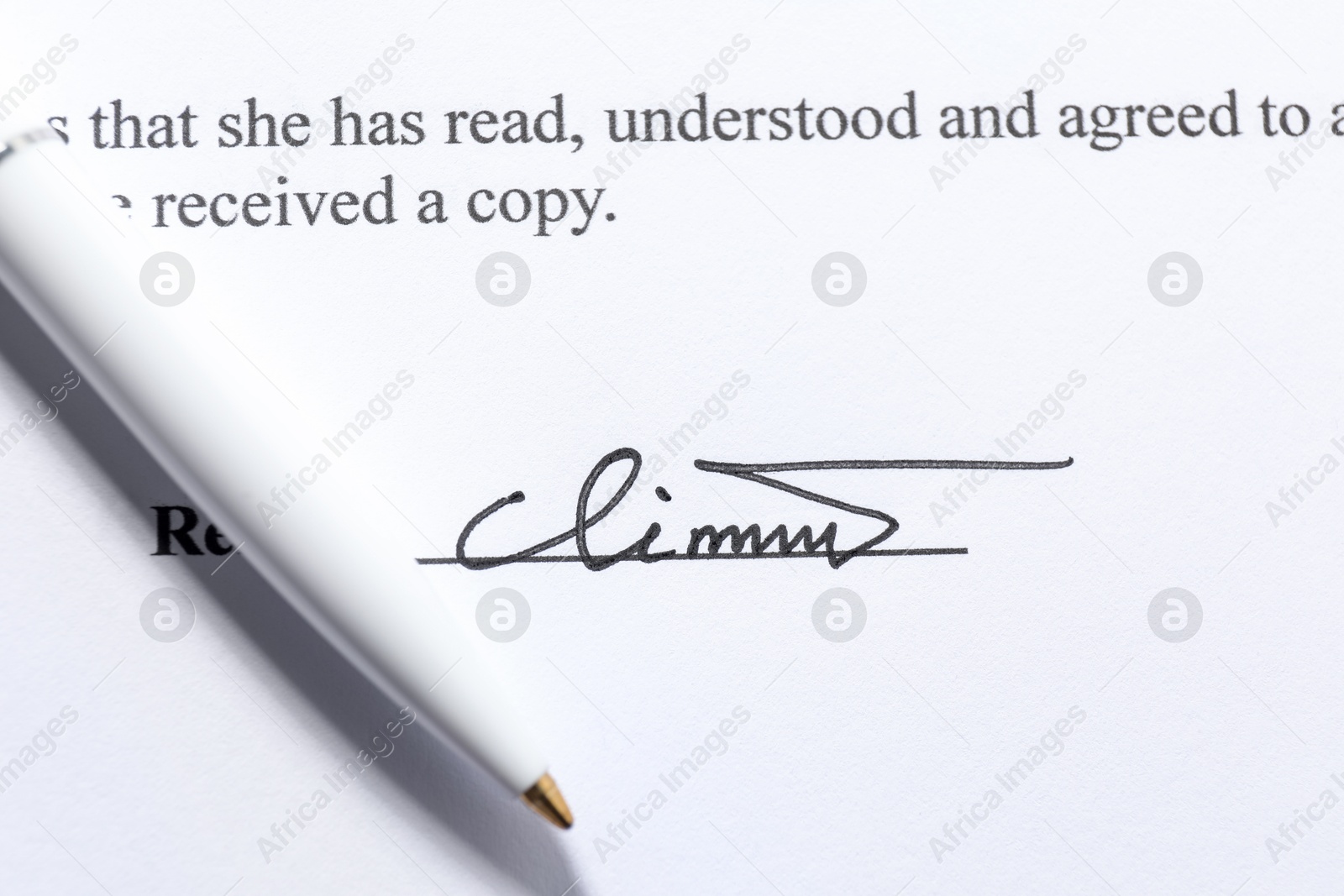 Photo of Signature and pen on paperwork, closeup view