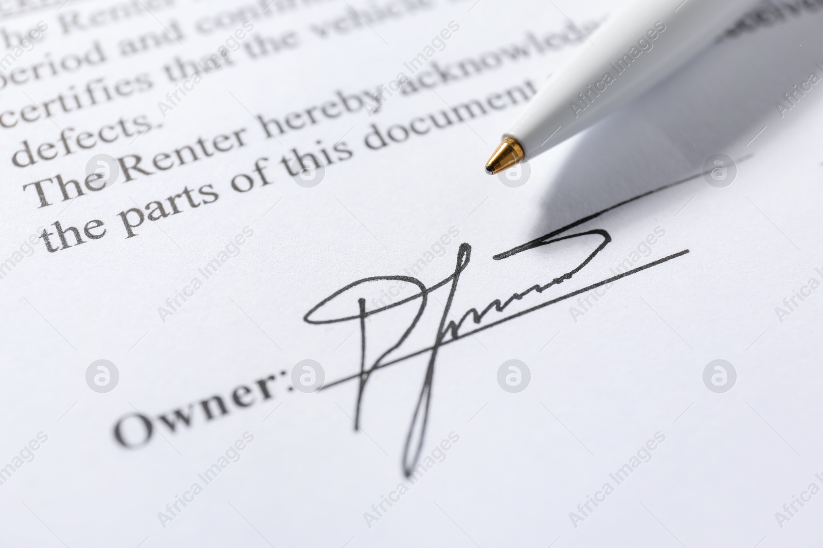 Photo of Signature and pen on paperwork, closeup view