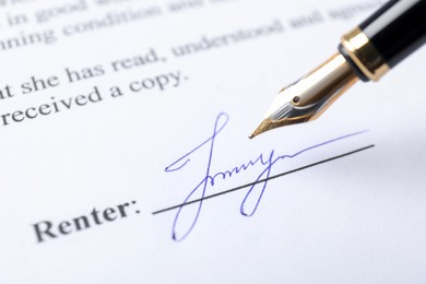 Photo of Signature and fountain pen on paperwork, closeup view