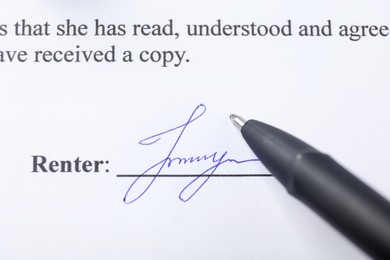 Photo of Signature and pen on paperwork, closeup view