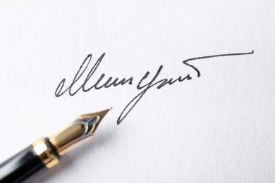 Photo of Fountain pen and signature on white paper, closeup