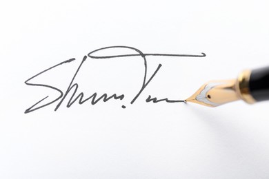 Photo of Fountain pen and signature on white paper, closeup