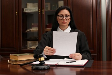 Photo of Judge with document at table in office