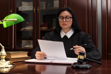 Photo of Judge with document at table in office