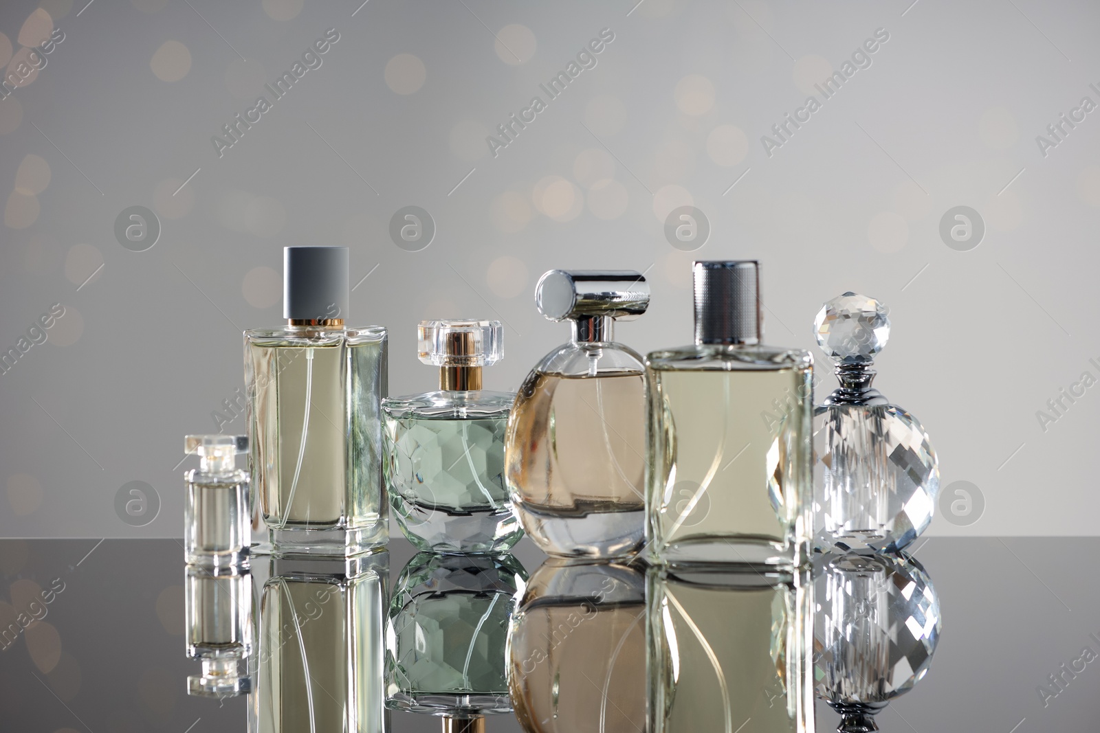 Different luxury perfumes on glass surface. Bokeh effect Photo of Different luxury perfumes on glass surface. Bokeh effect