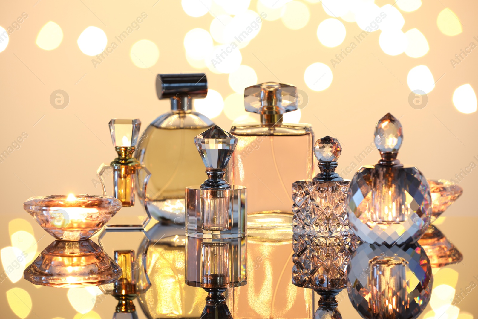 Different luxury perfumes on glass surface. Bokeh effect Photo of Different luxury perfumes on glass surface. Bokeh effect