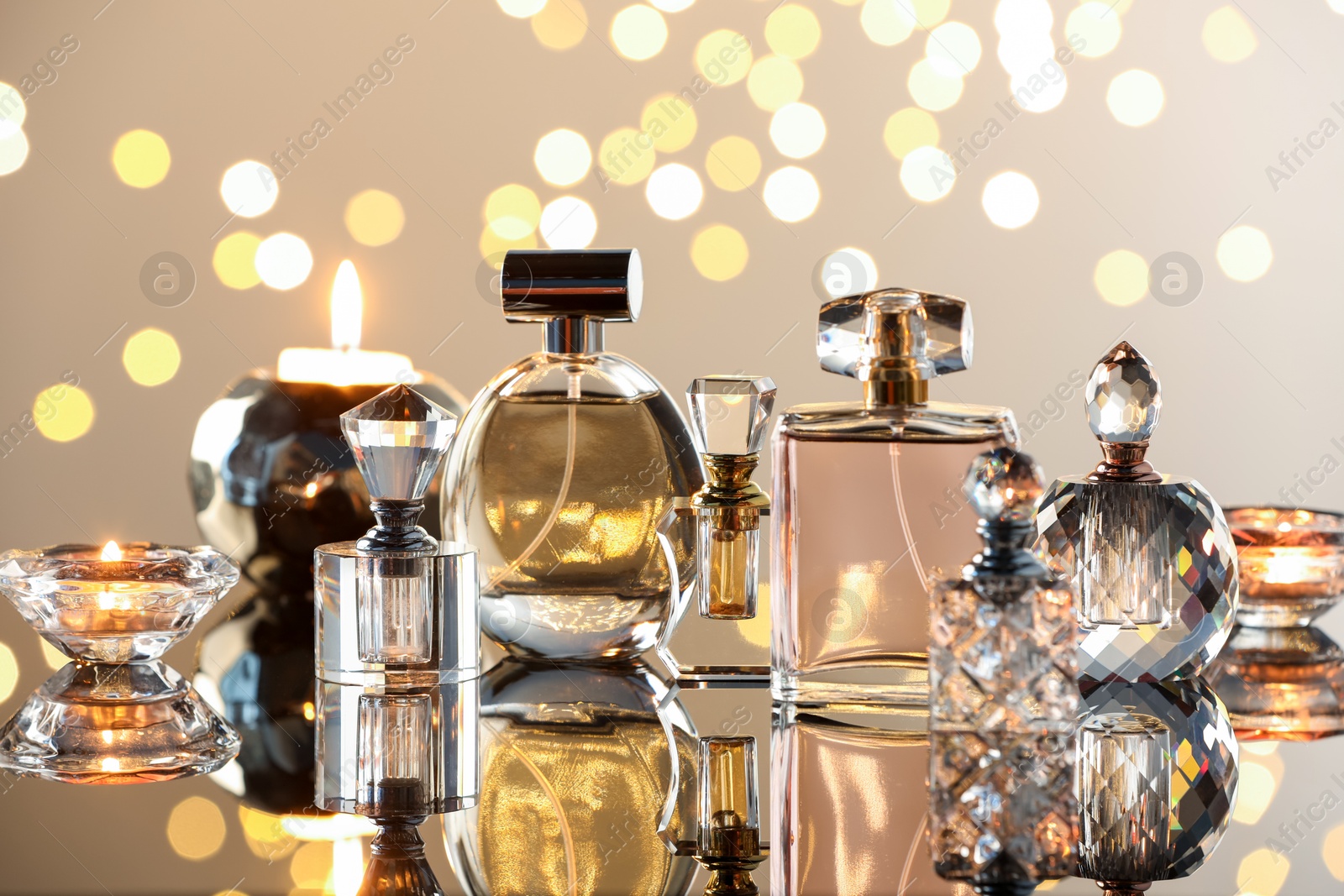 Different luxury perfumes on glass surface. Bokeh effect Photo of Different luxury perfumes on glass surface. Bokeh effect