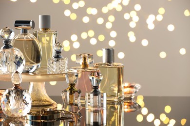 Photo of Different luxury perfumes on glass surface. Bokeh effect