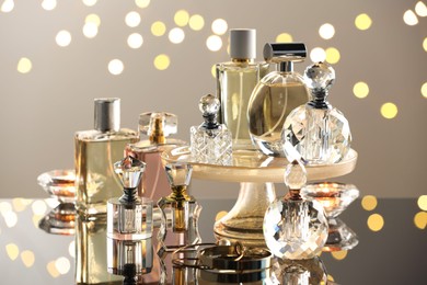 Photo of Different luxury perfumes on glass surface. Bokeh effect