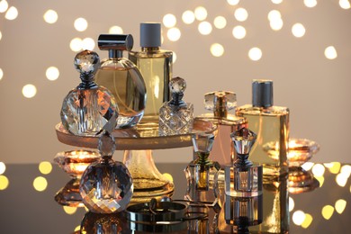 Photo of Different luxury perfumes on glass surface. Bokeh effect