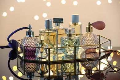 Photo of Different luxury perfumes on glass surface. Bokeh effect