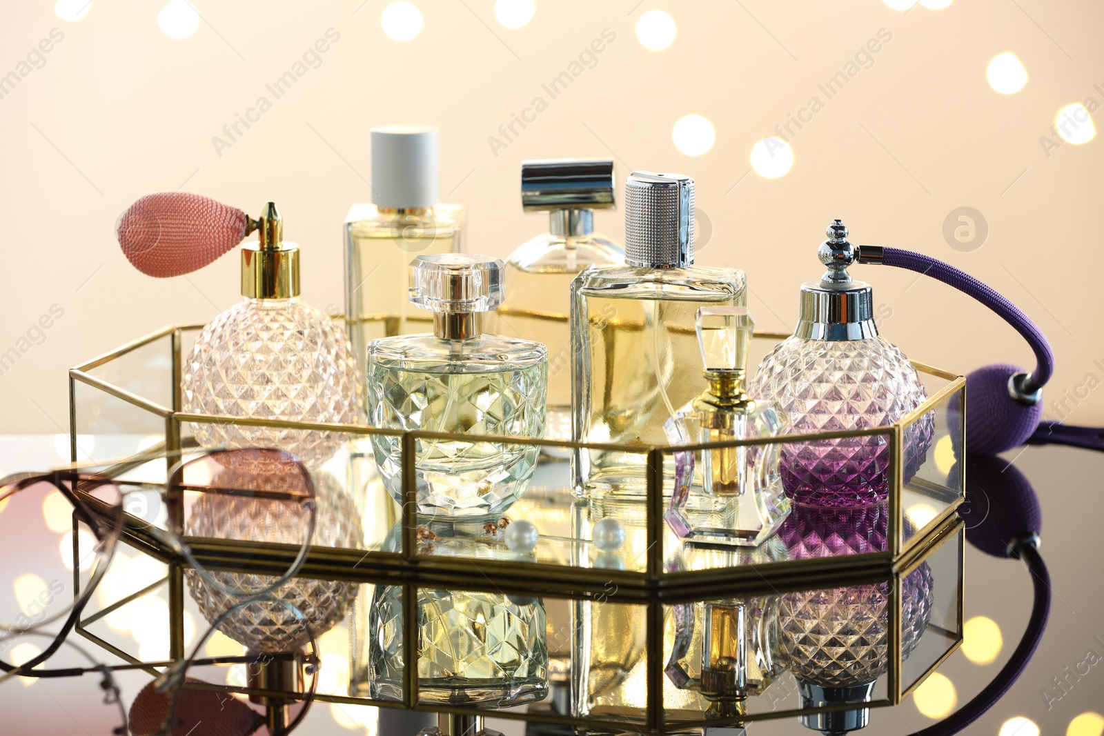 Different luxury perfumes on glass surface. Bokeh effect Photo of Different luxury perfumes on glass surface. Bokeh effect