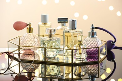 Photo of Different luxury perfumes on glass surface. Bokeh effect