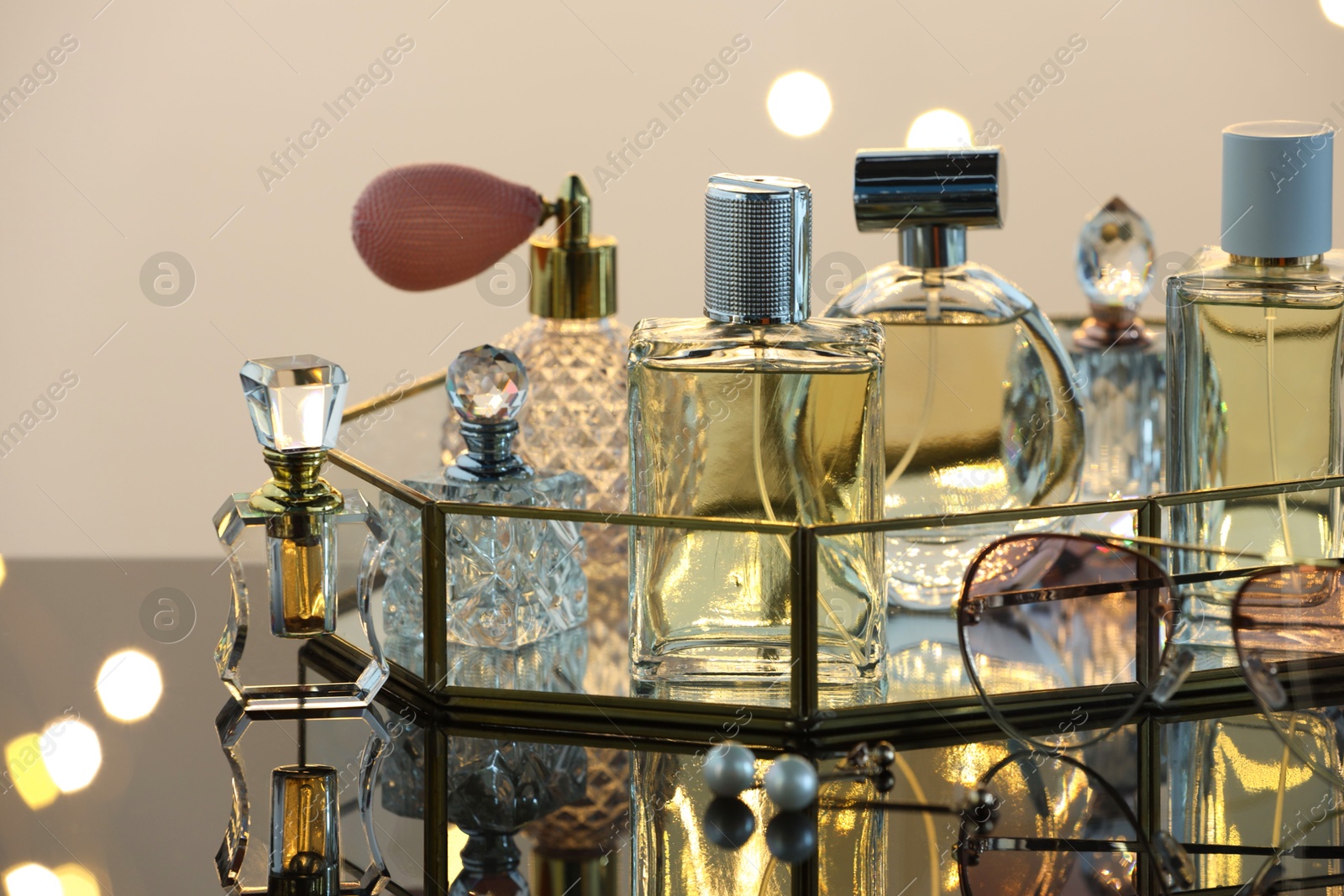 Different luxury perfumes on glass surface, closeup. Bokeh effect Photo of Different luxury perfumes on glass surface, closeup. Bokeh effect
