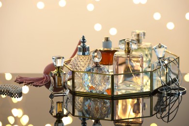 Photo of Different luxury perfumes on glass surface. Bokeh effect
