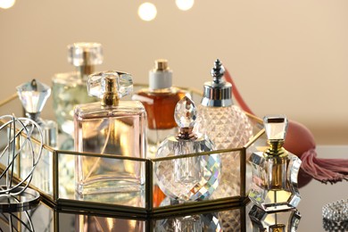 Photo of Different luxury perfumes on glass surface, closeup. Bokeh effect