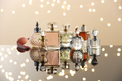 Photo of Different luxury perfumes on glass surface. Bokeh effect