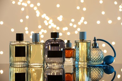 Photo of Different luxury perfumes on glass surface. Bokeh effect
