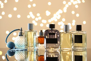 Photo of Different luxury perfumes on glass surface. Bokeh effect