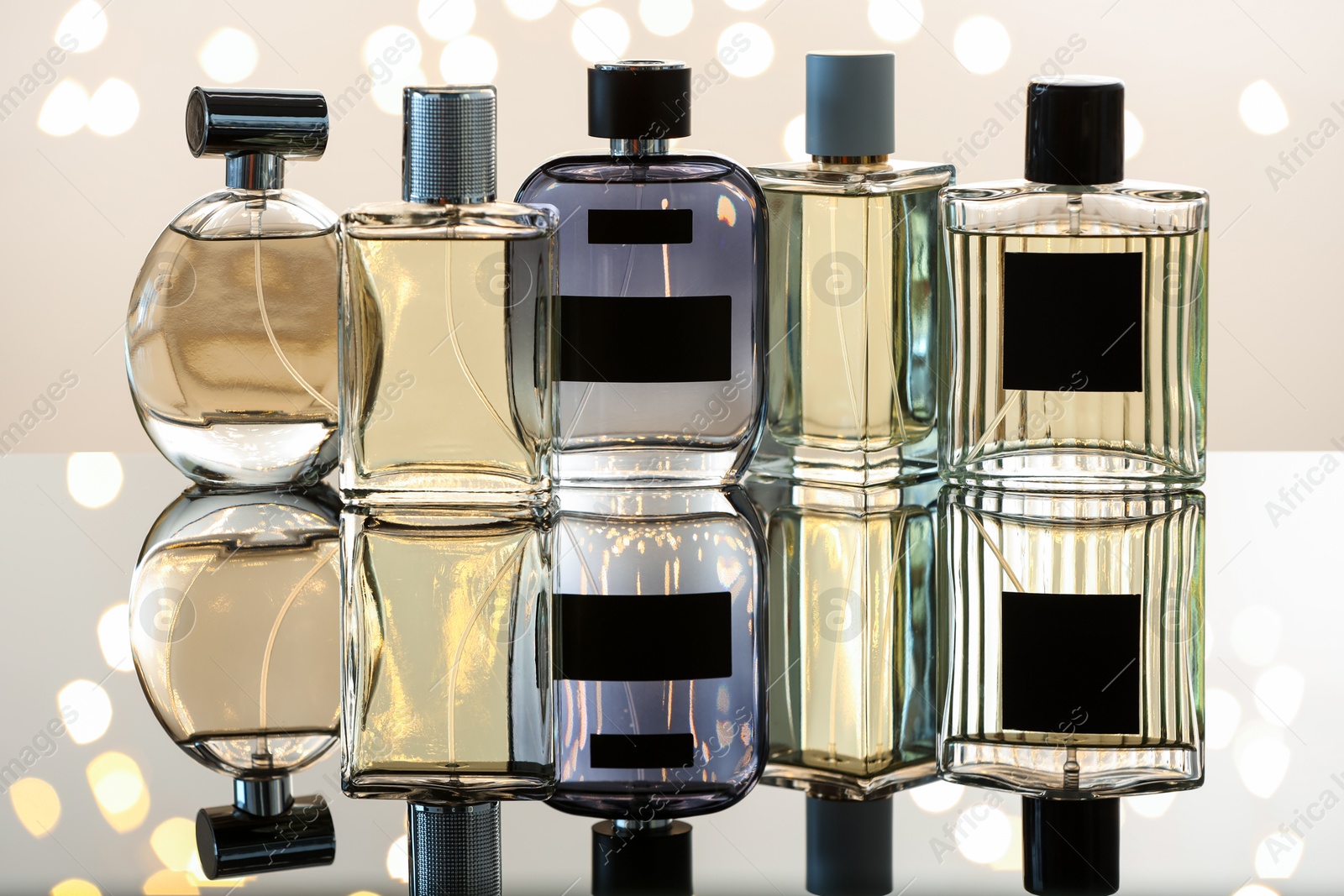 Different luxury perfumes on glass surface. Bokeh effect Photo of Different luxury perfumes on glass surface. Bokeh effect