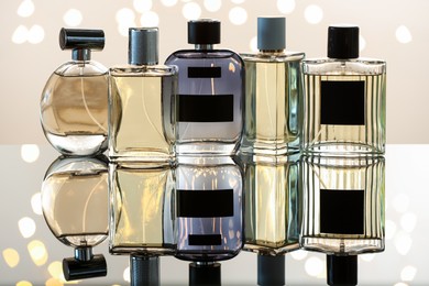 Photo of Different luxury perfumes on glass surface. Bokeh effect