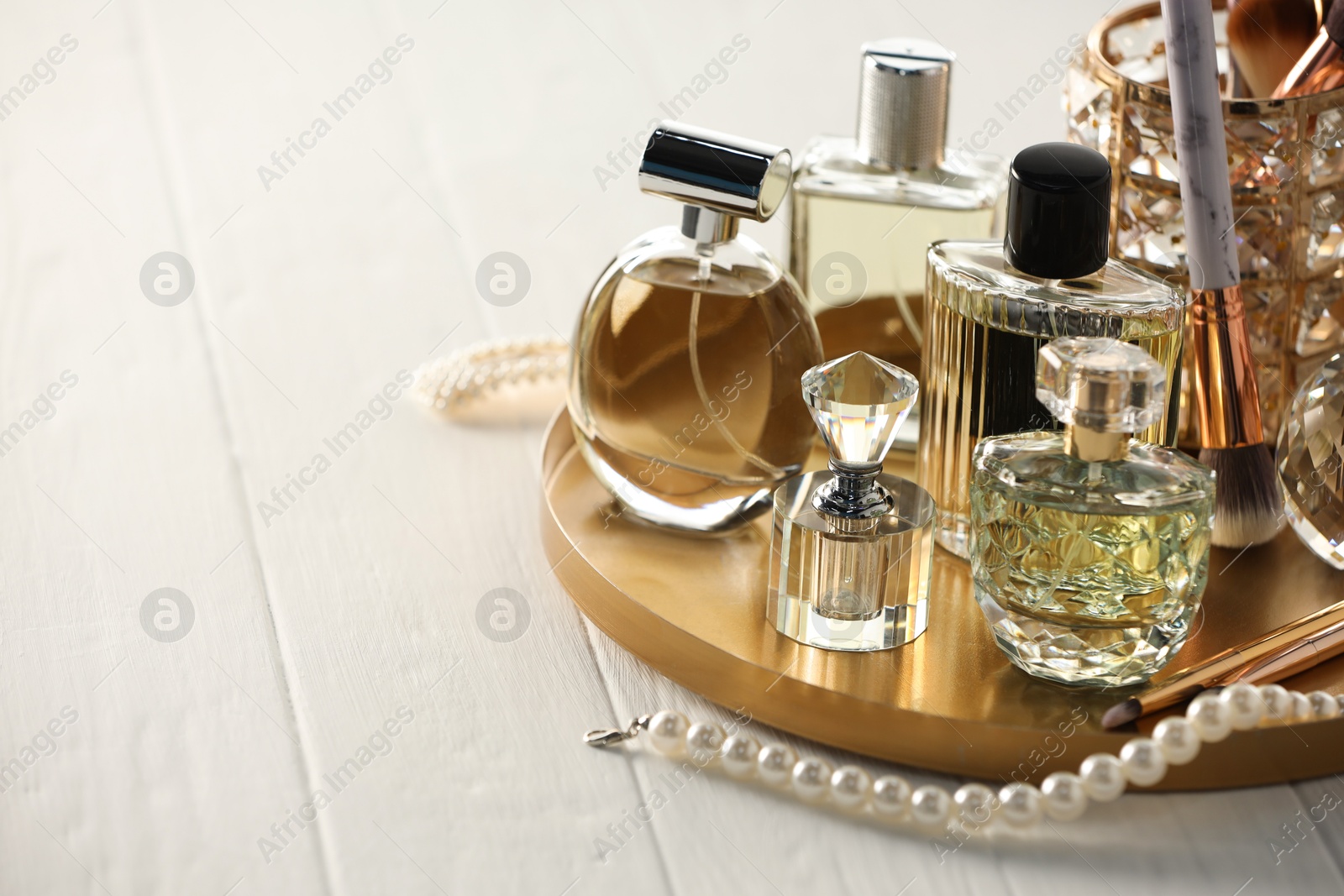 Different luxury perfumes on white wooden table. Space for text Photo of Different luxury perfumes on white wooden table. Space for text