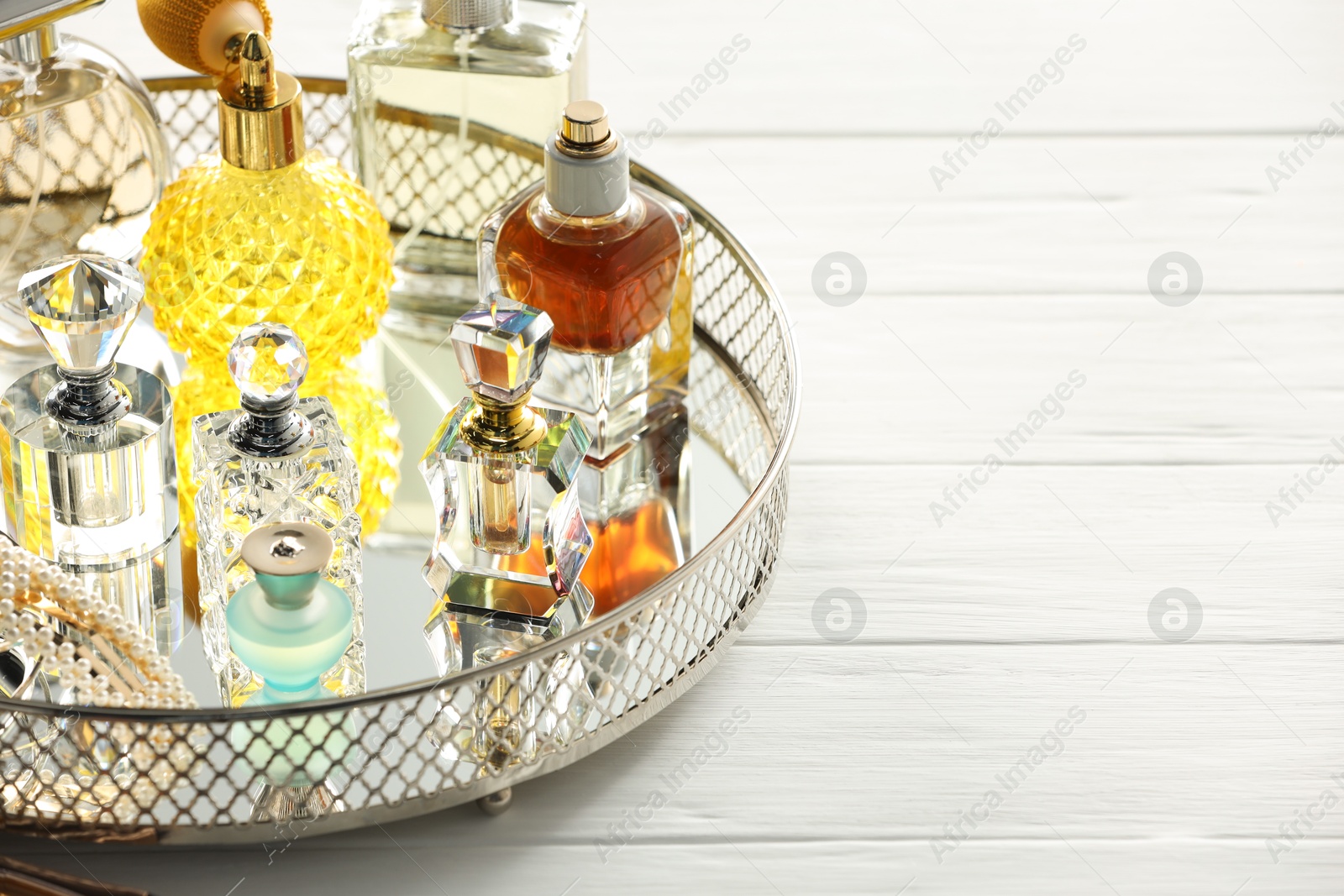 Different luxury perfumes on white wooden table. Space for text Photo of Different luxury perfumes on white wooden table. Space for text