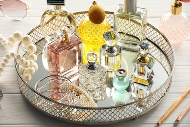 Photo of Different luxury perfumes on white wooden table