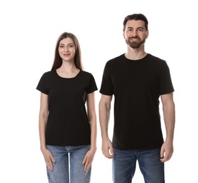 Photo of Woman and man wearing blank black t-shirts on white background. Mockup for design