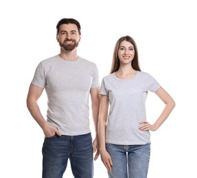 Photo of Woman and man wearing blank t-shirts on white background. Mockup for design