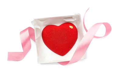 Photo of Heart shaped chocolate in box and pink ribbon isolated on white, top view