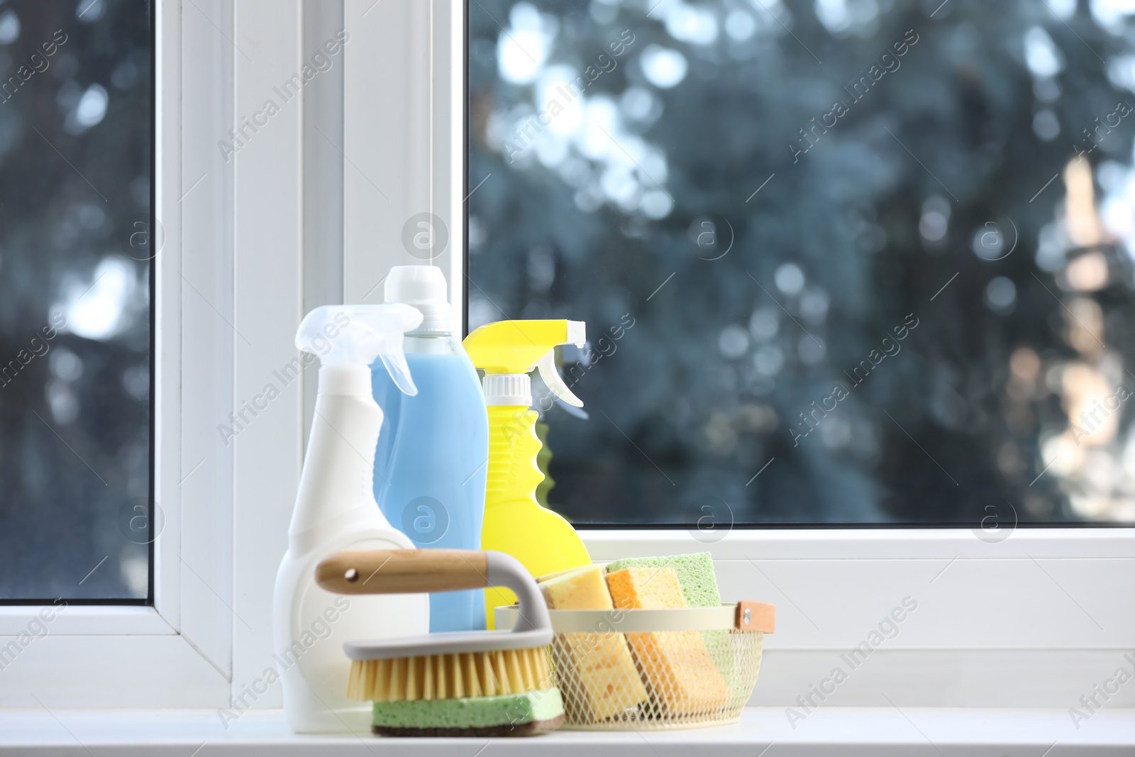 Photo of Cleaning products and supplies near window indoors