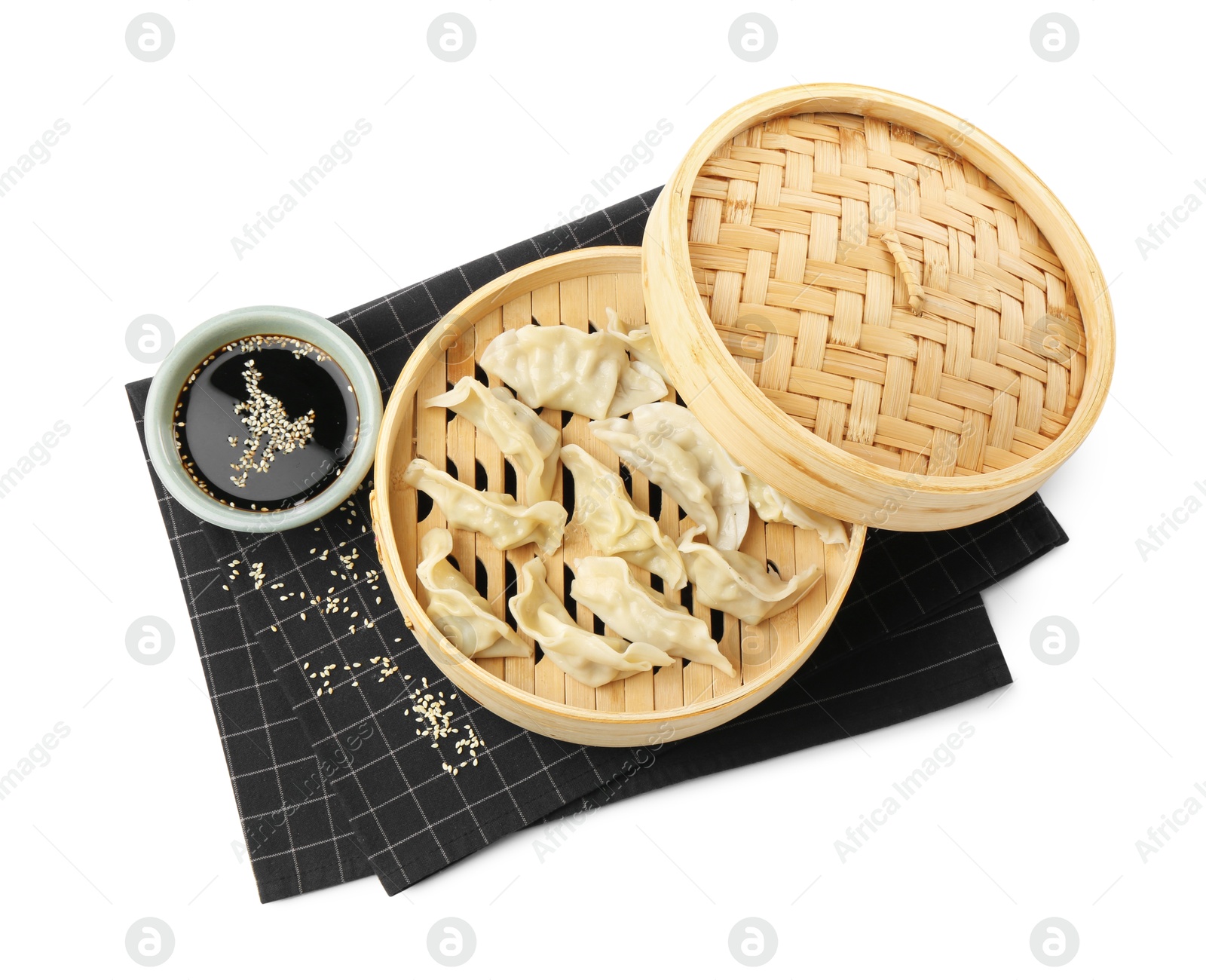 Photo of Tasty boiled gyoza (dumplings) with soy sauce and sesame on white background, top view