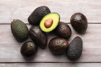 Photo of Fresh ripe avocados on light wooden table, flat lay