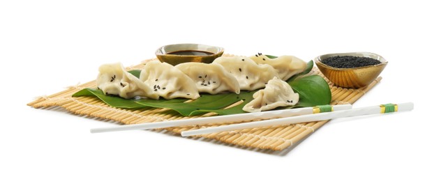 Photo of Tasty boiled gyoza (dumplings) with soy sauce, chopsticks and sesame on white background