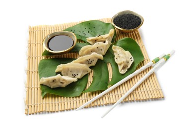 Photo of Tasty boiled gyoza (dumplings) with soy sauce, chopsticks and sesame on white background