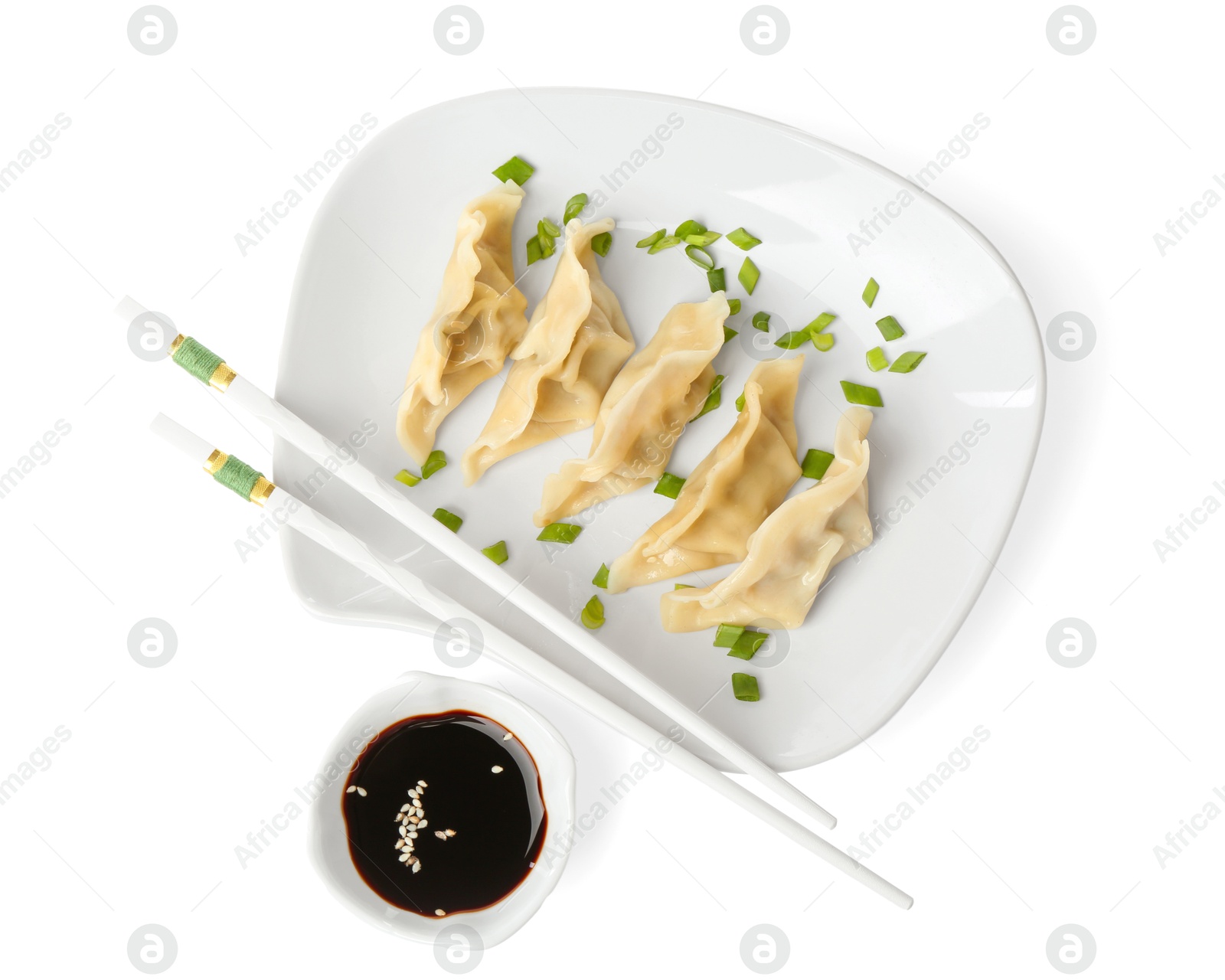 Photo of Tasty boiled gyoza (dumplings) with green onion, soy sauce and chopsticks on white background, top view